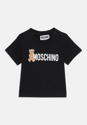 Camiseta de bebé de algodón negra con mangas cortas, cuello redondo, texto en blanco "MOSCHINO" y un gráfico de un oso de peluche marrón en el frontal.