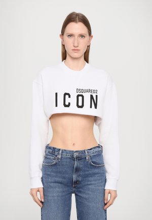 Bijela skraćena dukserica s printom "DSQUARED2 ICON" u crnoj boji. Uparena s plavim trapericama visokog struka. Glatka tekstura, pripijen dizajn.