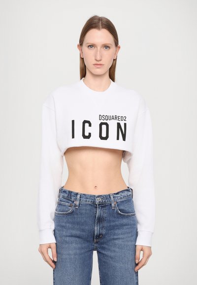 Sweatshirt blanc court avec "DSQUARED2 ICON" imprimé en noir. Assorti à un jean en denim bleu taille haute. Texture lisse, design ajusté.