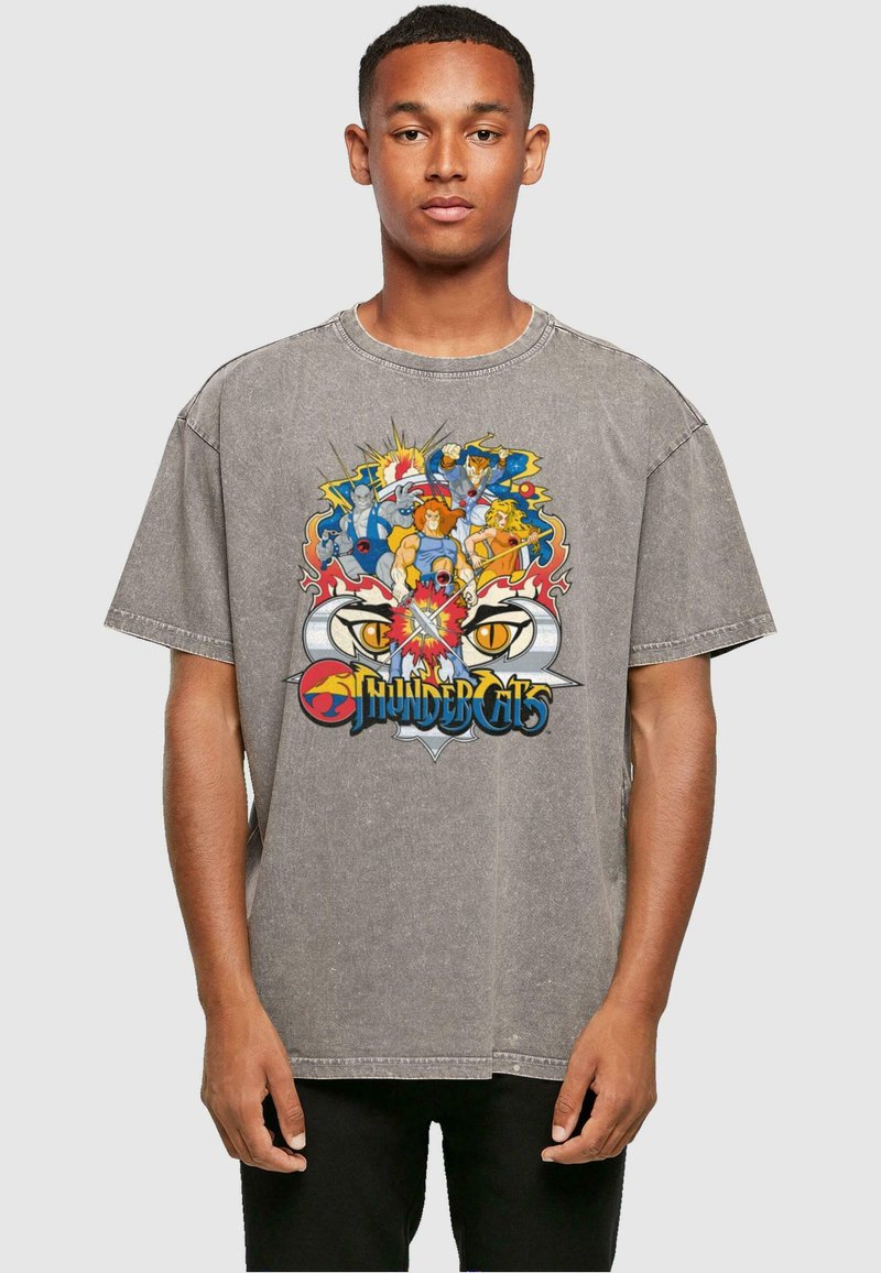 Grafisch oversized t-shirt in grijs, met een kleurrijk "ThunderCats" ontwerp waarin personages omringd zijn door vlammen en een prominent logo.