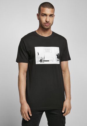 Black cotton t-shirt featuring a front graphic design of a room with the text "HOME SICK" and minimalist line art of furniture.