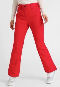 Pantalon de neige rouge à coupe droite, en tissu résistant, avec une poche zippée et un logo de marque sur la cuisse.
