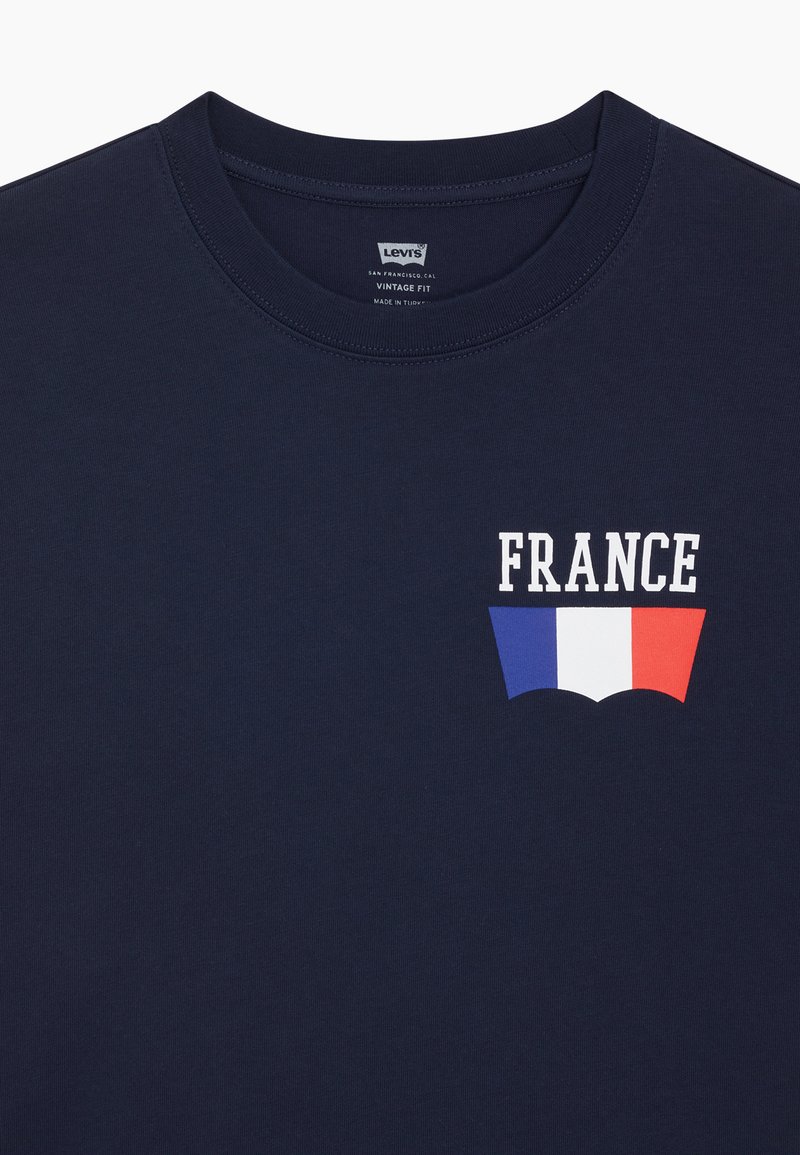 Levi's tamnoplava majica s tekstom "FRANCE" i francuskom zastavom u bijeloj, plavoj i crvenoj boji na lijevoj strani prsa, vintage fit etiketa unutar ovratnika.