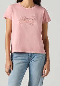 T-shirt en coton rose à manches courtes avec un logo Levi's brodé et le numéro 73, doté d'une coupe décontractée et d'une finition texturée subtile.