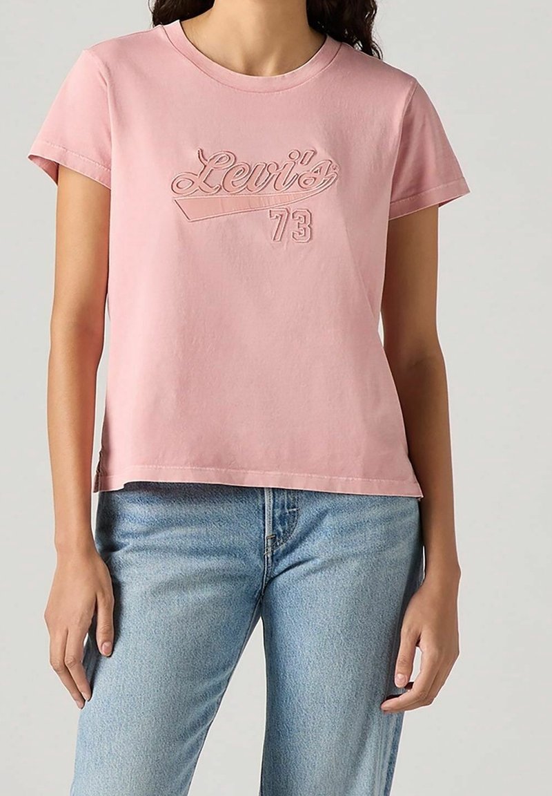 T-shirt en coton rose à manches courtes avec un logo Levi's brodé et le numéro 73, doté d'une coupe décontractée et d'une finition texturée subtile.