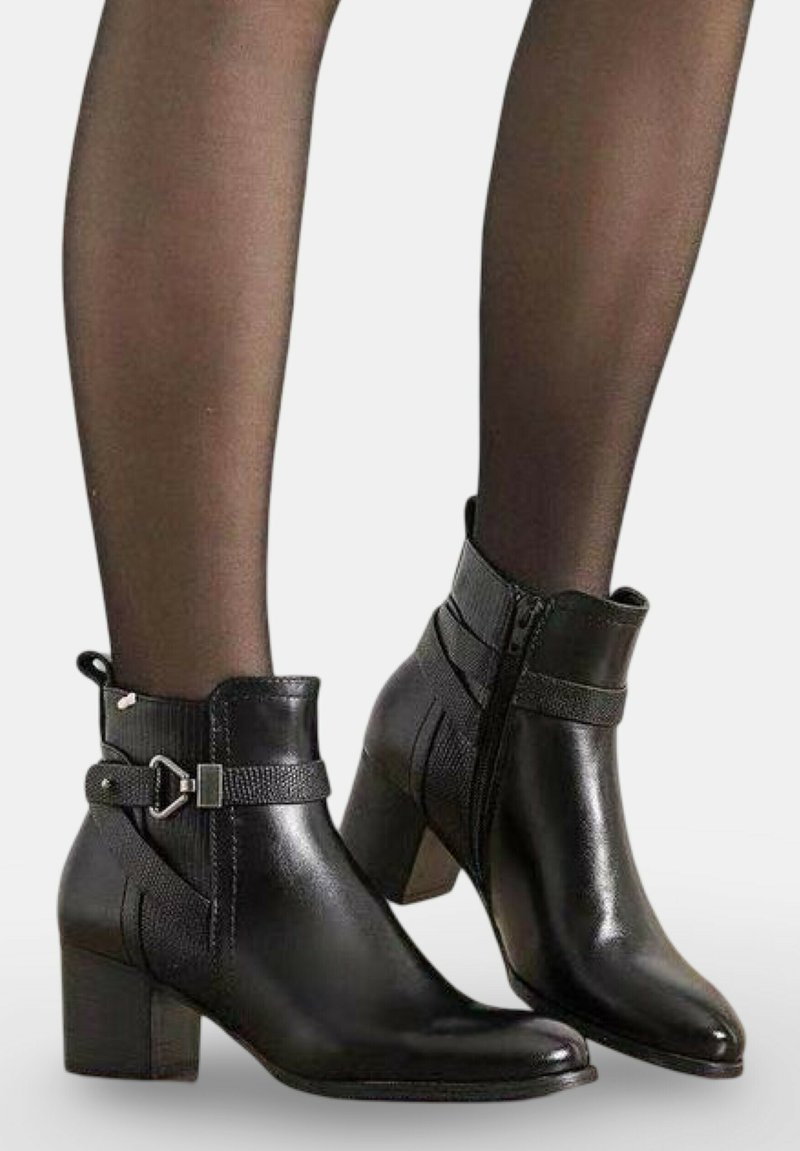 Bottines en cuir noir avec fermeture éclair, accents texturés, détail de boucle et talon épais. Fini de surface lisse.