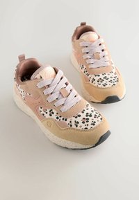 Sneakers in soft pink and beige suede with a speckled white sole. Features white laces and a patterned canvas upper with green and black spots.
