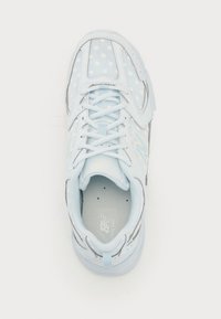 Vaaleansininen lenkkari, jossa on pilkkukuvio, verkkopäällinen, nauhakiristys, pehmustettu nilkkasauma ja hillitty brändäys kielelle ja sivuille.