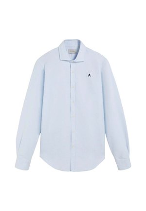 Camisa de manga larga azul claro hecha de tela, con un collar tipo button-down y un pequeño logotipo de calavera negra en el lado izquierdo del pecho.