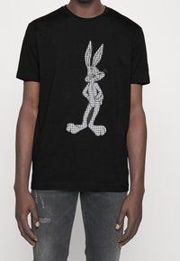 Black cotton t-shirt featuring a white houndstooth pattern of a rabbit graphic, short sleeves, and a classic crew neckline.