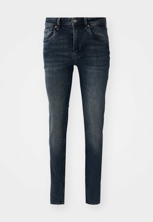 Jean en denim bleu foncé avec une coupe slim, un design à cinq poches, des jambes droites et des coutures contrastées, doté d'une fermeture à bouton et à zip.