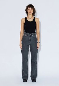 Jeans med hög midja och raka ben i mörkblå denim. Har en klassisk femficksdesign och detaljer i metall.