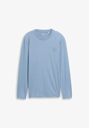 T-shirt à manches longues bleu clair en tissu doux, avec un col rond et un petit graphic circulaire sur la poitrine.