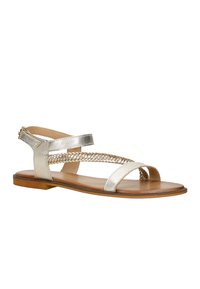 Sandalo piatto di metallo argento con design della fascia intrecciata. Punta e tallone aperti, con insole color tan e suola di un marrone chiaro.