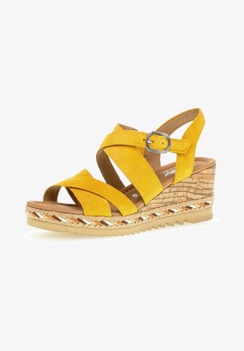Sandale compensée en daim jaune avec brides croisées, boucle argentée, plateforme effet liège et détail tressé sur le bord de la semelle.