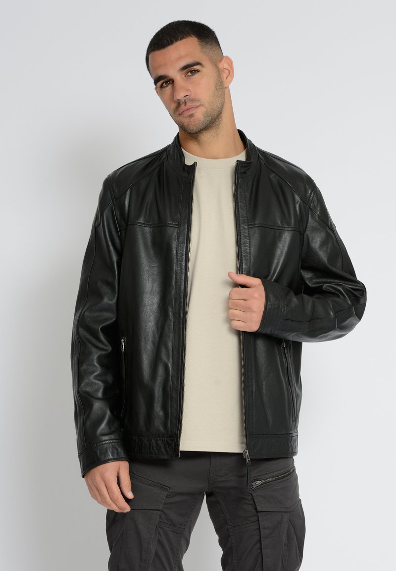 Schwarze Lederjacke mit einem Reißverschluss vorne, stehendem Kragen und zwei seitlichen Taschen. Glatte Textur mit Nahtdetails und einer lässigen Passform.