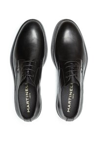 Zapatos de vestir de cuero negro con una textura suave, punta redonda y diseño de cordones. Presentan un sutil branding en la plantilla y costura delineada.