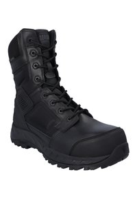 Botte tactique noire combinant cuir lisse et tissu texturé, embout renforcé et semelle en caoutchouc robuste avec motif de bande de roulement.