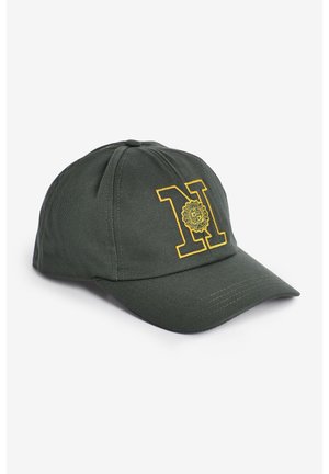 Casquette de baseball vert foncé avec la lettre brodée jaune "N" et un emblème circulaire décoratif sur le panneau avant.