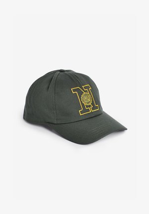 Mørkegrøn baseballkasket med gul broderet bogstav "N" og et dekorativt cirkulært emblem på frontpanelet.