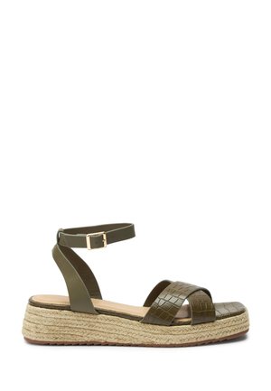 Sandale compensée vert olive avec bride à la cheville, lanières croisées texturées et semelle plateforme en jute tressé.