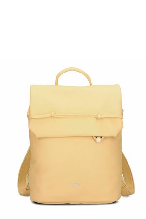 Zaino beige chiaro con chiusura a patta superiore, dettaglio di asola e pomello frontale, spallacci imbottiti e piccolo logo del marchio al centro in basso.