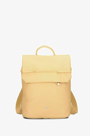 Sac à dos beige clair avec fermeture à rabat supérieur, boucle frontale et détail bouton, bretelles rembourrées, et petit logo de la marque en bas au centre.