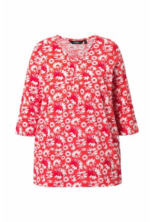 Blusa rossa con scollo a V e maniche a tre quarti, caratterizzata da un motivo floreale a margherite bianche e rosa su tutta la superficie.