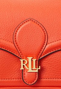Rode leren handtas met een gestructureerd oppervlak, gouden beslag met het "RLL" logo en contrasterende zwarte stiksels langs de randen.