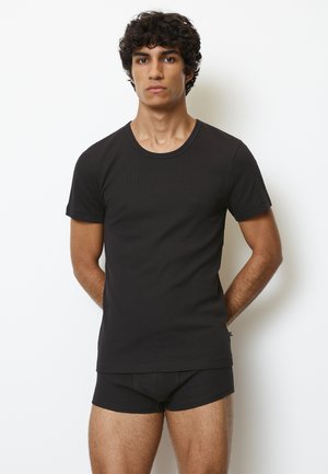 Schwarzes, eng anliegendes T-Shirt mit kurzen Ärmeln und Rundhalsausschnitt, kombiniert mit passenden schwarzen Unterhosen, beide aus glattem, geschmeidigem Stoff.