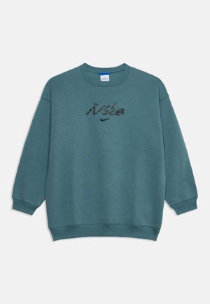Sweat-shirt Nike bleu sarcelle à manches longues, poignets et ourlet côtelés, avec un logo Nike noir et un texte texturé sur la poitrine.