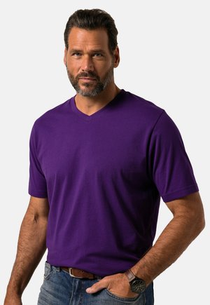 Camiseta de cuello en V morada hecha de algodón ligero; mangas cortas; textura suave; combinada con jeans de mezclilla azul y un reloj de pulsera marrón.