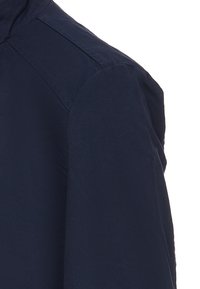 Camicia blu navy con una texture liscia, dotata di un colletto classico e cuciture sulle spalle per una maggiore struttura. Dettaglio ravvicinato del tessuto.