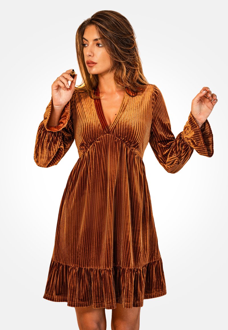 Vestido de terciopelo marrón con rayas verticales, escote en V profundo, mangas largas acampanadas y un dobladillo con volantes. Textura suave con un ligero brillo.