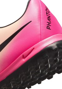 A Nike Phantom focicipő gradient rózsaszín felsőrésszel rendelkezik, texturált felülettel, fekete swoosh logóval és fekete gumitalppal, ami tüskékkel biztosít tapadást.