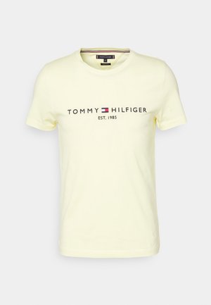 T-shirt en coton jaune à manches courtes avec "TOMMY HILFIGER EST. 1985" imprimé en couleurs sombres, col rond et coupe régulière.