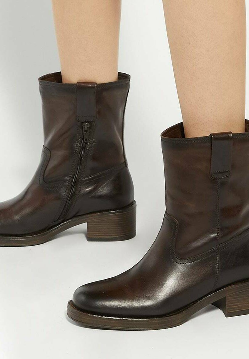 Brown leather ankle boots with a side zipper, a rounded toe, and a low stacked heel. Features smooth texture and minimal detailing.