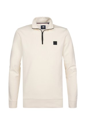 Pulóver de manga larga color crema con cremallera frontal hasta un cuarto, cuello alto, puños y dobladillo acanalados, y un pequeño logo cuadrado negro en el pecho.