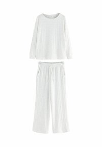 Ljusgrå loungewear-set bestående av en långärmad topp och vida byxor, med en ribbad textur och ett elastiskt midjeband.