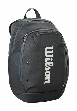 Sac à dos en tissu gris avec un grand logo "Wilson" blanc. Offre plusieurs poches zippées et une poignée de transport en haut. Surface texturée.