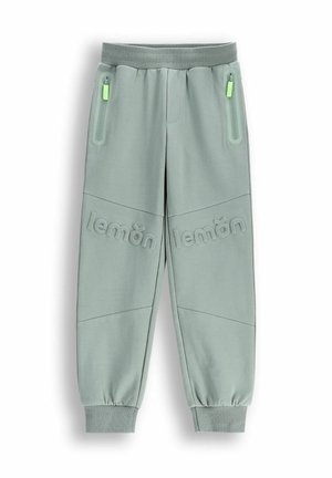 Jasnozielone spodnie dresowe z żebrowanym paskiem w talii, kieszeniami zapinanymi na zamek oraz wypukłym napisem "lemon" na nogawkach. Gładka tekstura, dopasowany krój.