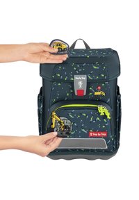 Dark blue backpack with colorful speckled pattern, zipper pocket, and various construction-themed patches attached on the front.