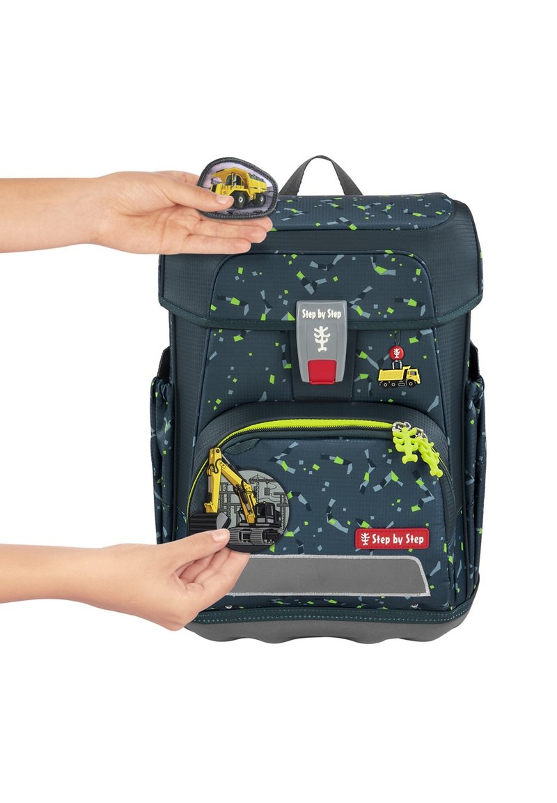 Dark blue backpack with colorful speckled pattern, zipper pocket, and various construction-themed patches attached on the front.