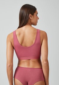 Roze katoenen sportbeha met brede banden, voorzien van een ronde halslijn en een elastische band, gecombineerd met bijpassende hoogopgetrokken slipjes.