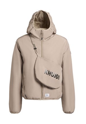 Jachetă bej cu glugă, cu fermoar frontal, manșete elastice și o geantă crossbody asortată, pe care este inscripționat „KHUJO 2001” cu text negru. Textură netedă.