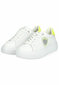 Sneakers bianchi in pelle con suola testurizzata, caratterizzati da un accento giallo neon sul tallone e un dettaglio in rete sul lato. Design con lacci.