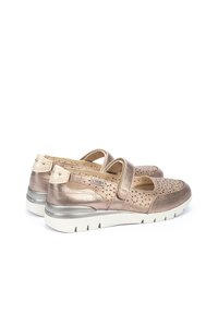 Des chaussures en bronze métallique avec un dessus perforé, une sangle réglable et une semelle flexible blanche. Elles présentent un talon plat et des accents décoratifs en métal.