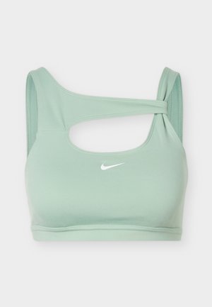 Šviesiai žalias sportinis liemenėlė su asimetriniu išpjovu ir mazgo detalė ant vieno peties, priekyje centre su mažyčiu baltu Nike swoosh logotipu.