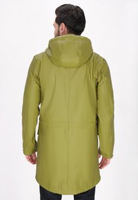 Kurtka wodoodporna w oliwkowym kolorze z kapturem, o gładkiej fakturze, średniej długości i kieszeniach bocznych, przedstawiona od tyłu.