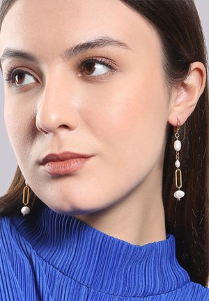 Goldfarbene Ohrringe mit länglichen rechteckigen Formen und Perlenakzenten, in einem hängenden Design und mit gemischten Texturen.